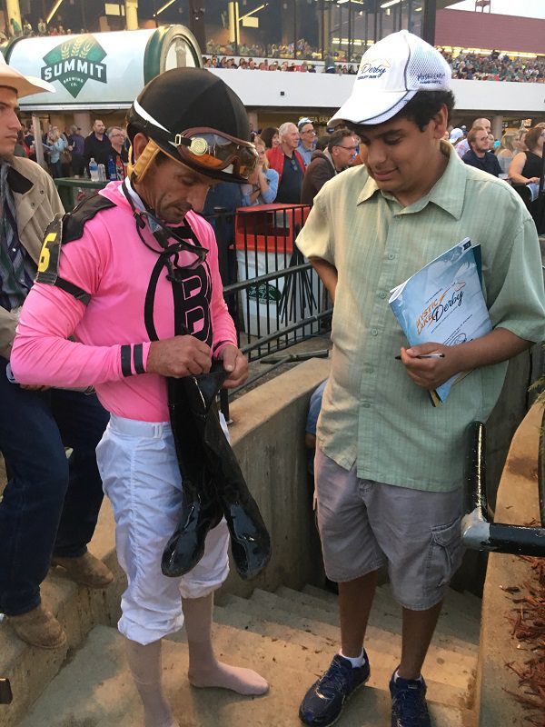 Albarado signs his riding boots for a young fan.